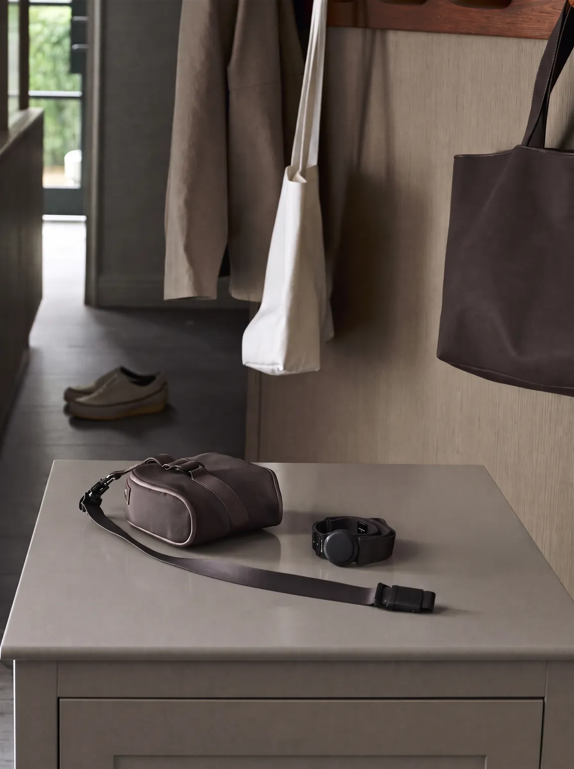 A slim activity monitor and walking bag laid out on a hallway console, ready for a walk.